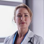 Portrait Of Mature Female Doctor Wearing White Coat In Hospital